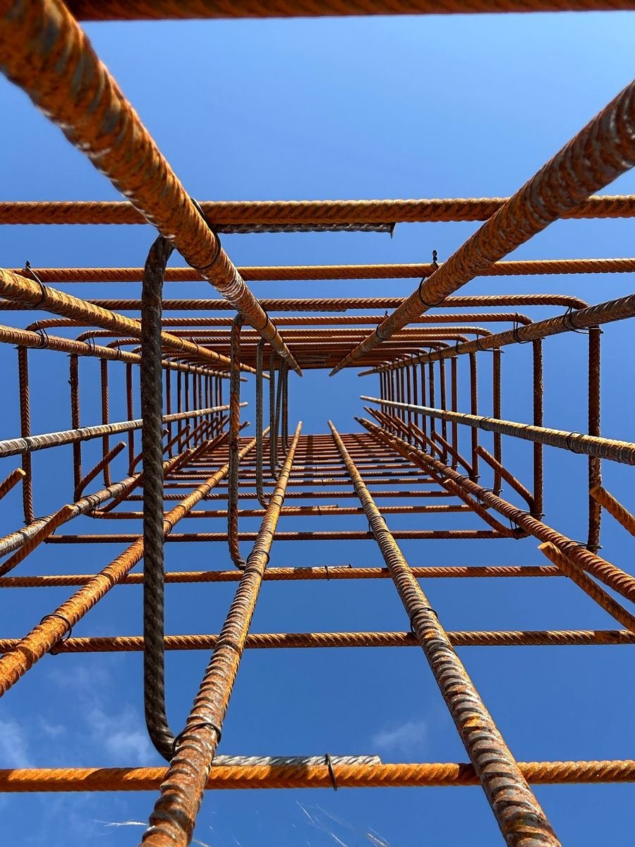 Steel reinforcement cage for a concrete column rising against a blue sky
