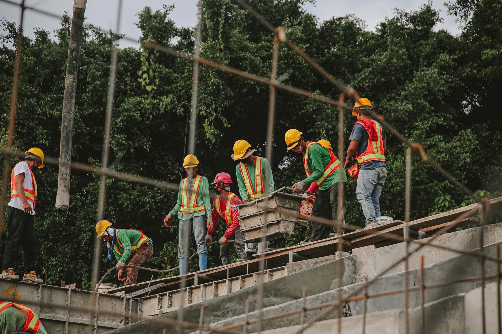 Site crew in hard hats and hi-vis placing concrete formwork