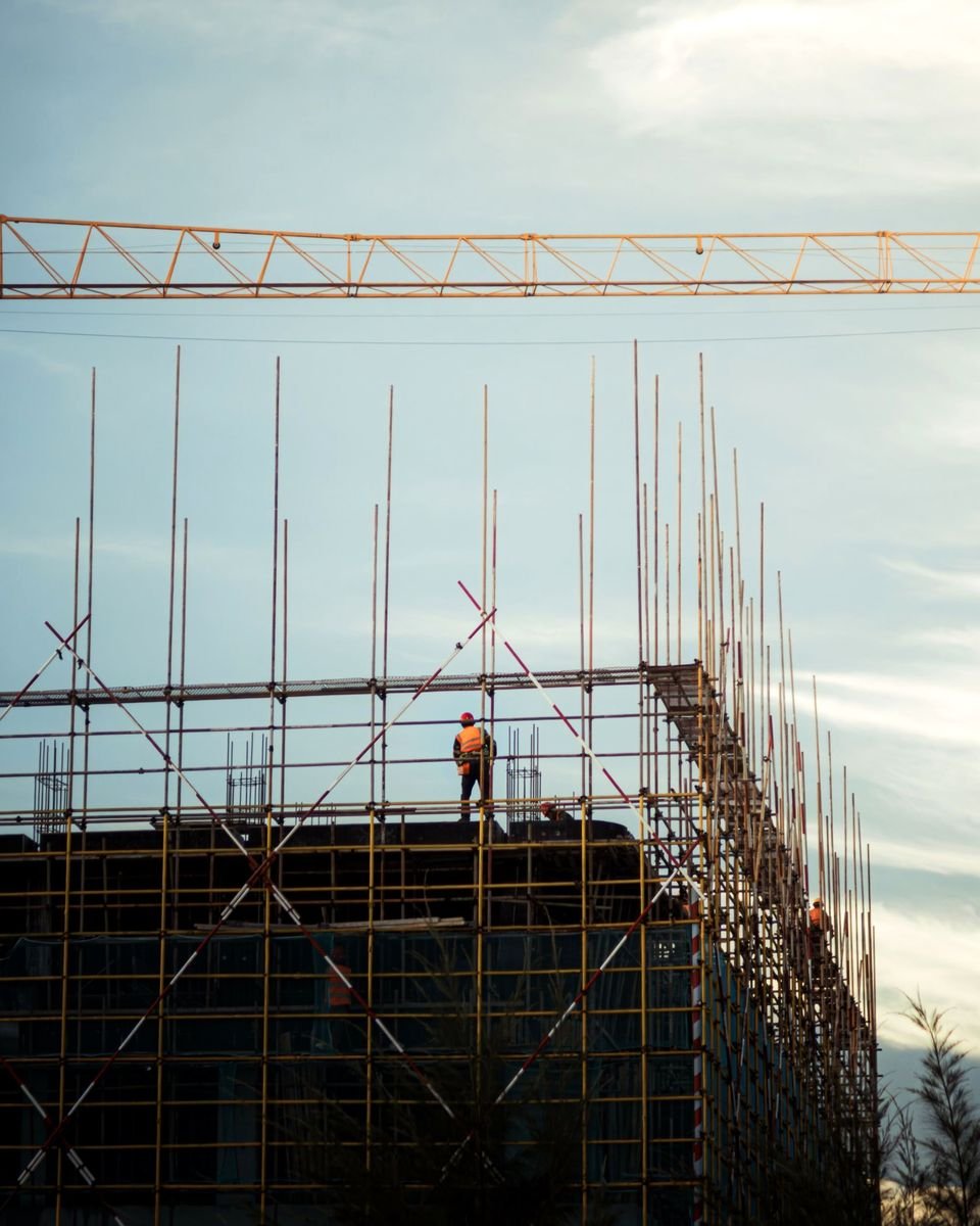 Scaffolder working on a scaffold deck against the sky