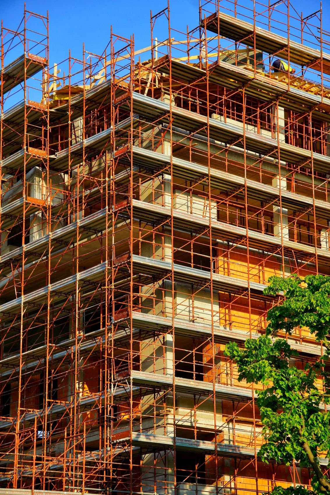Multi-storey building clad in steel scaffolding during construction